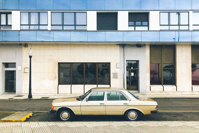 Side view of car on street against building