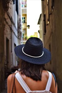 Rear view of woman wearing hat standing in city