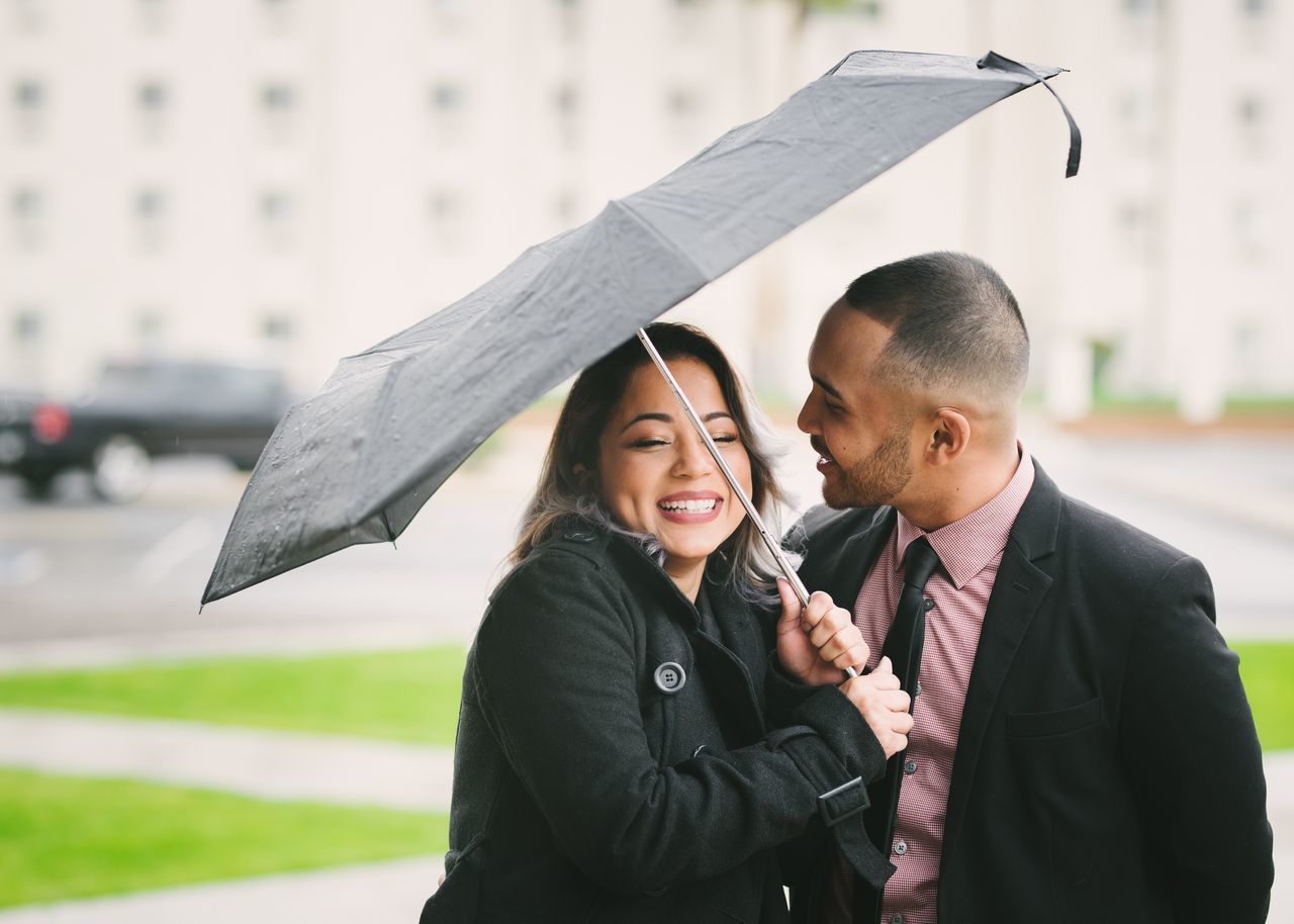 two people, rain, happiness, togetherness, smiling, adults only, young adult, women, wet, bonding, people, adult, young women, men, cheerful, outdoors, city, businessman, well-dressed, day