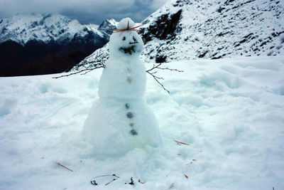 Cute snowman on top of a white snowy mountain with winter landscape