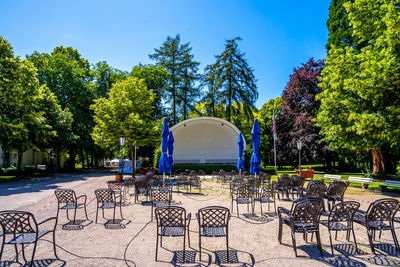 Chairs and table in park against blue sky