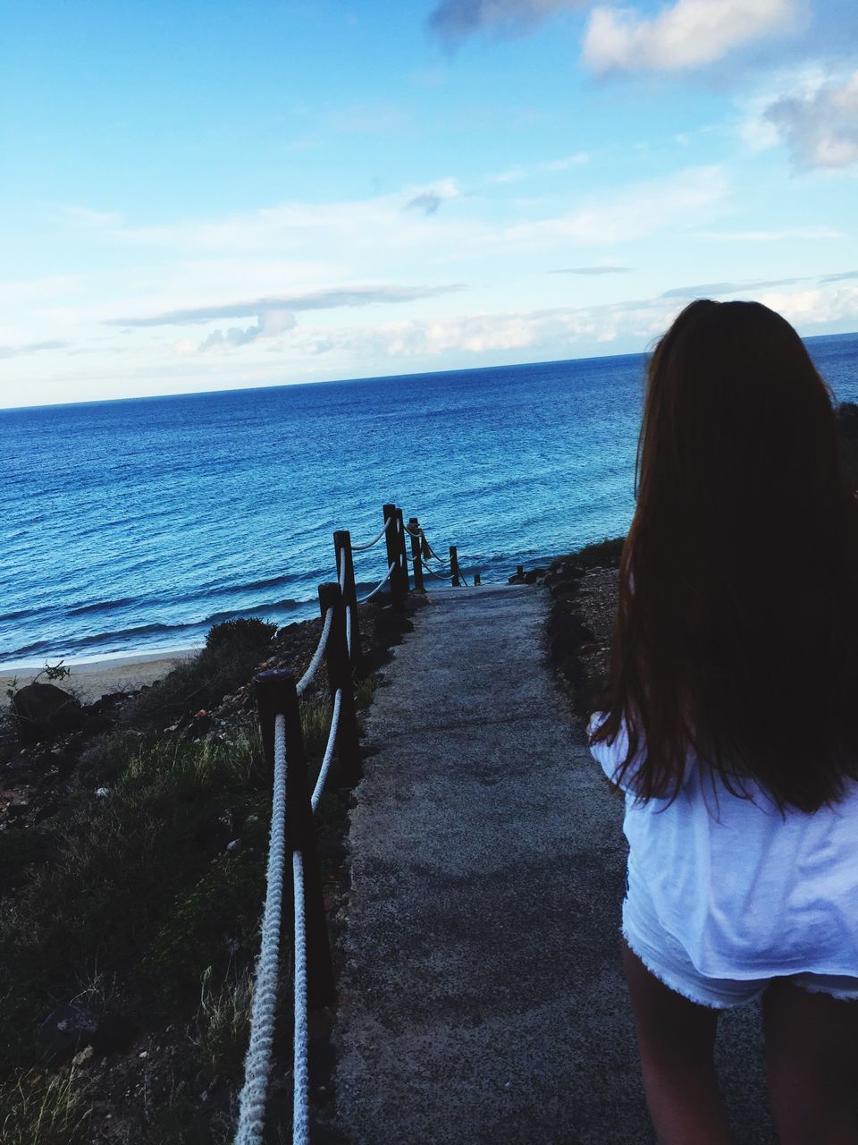 sea, water, horizon over water, sky, lifestyles, beach, tranquil scene, scenics, leisure activity, blue, tranquility, railing, rear view, beauty in nature, nature, people, shore, the way forward