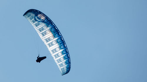 Low angle view of helicopter flying against clear blue sky