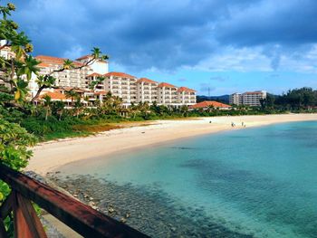 Buildings by swimming pool in city against sky