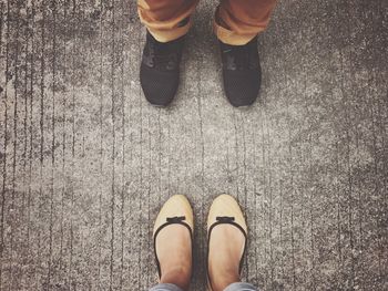 Low section of woman in front of man standing outdoors