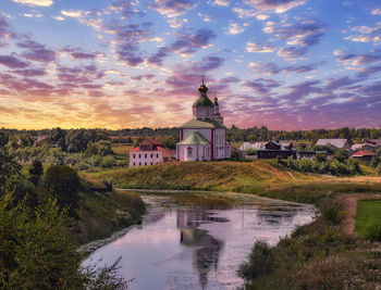 Sunset panorama of suzdal with river reflections and dramatic sky