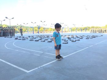 Full length of boy standing on promenade against sky