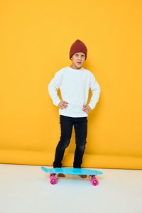 Portrait of girl standing against yellow background