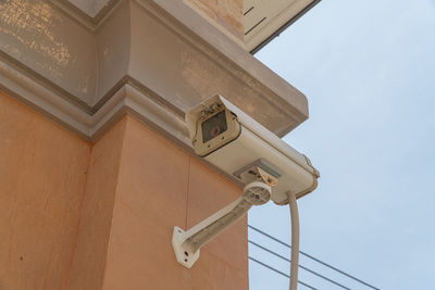 Low angle view of lamp on building against sky