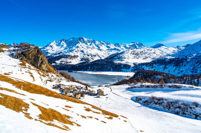 View of the village of grevasalvas, and lake sils, in engadine, switzerland, in winter.