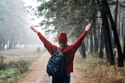 Weekend breaks and getaways in forests. stay close to nature. young woman in red hat and sweater