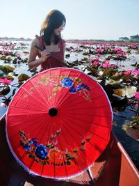 Woman with umbrella standing in water