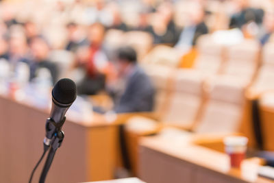 Close-up of microphone in foreground at business conference