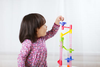 Side view of girl looking at toy