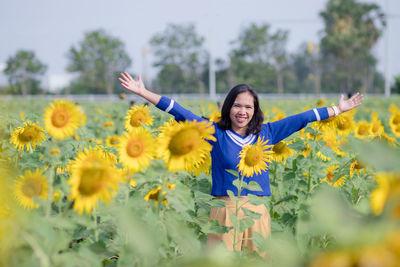 Woman with arms raised on field