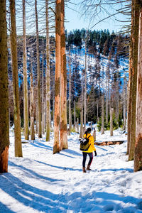 Woman walking on snow covered land during winter