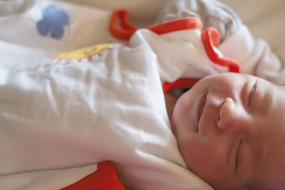 Close-up of cute baby girl sleeping on bed at home