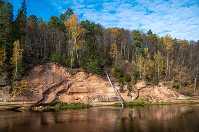 Devils rock and cave by the shores of the river gauja, surrounded by a autumn forest on a cloudy day