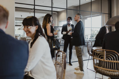 Female entrepreneur discussing with coworkers during party in office