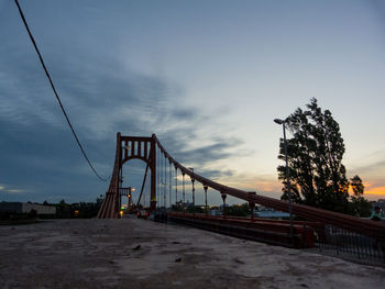View of suspension bridge against cloudy sky