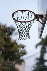 Low angle view of basketball hoop against trees