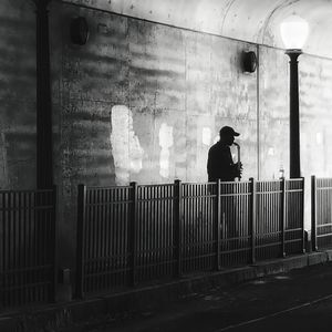 Side view of man standing against railing