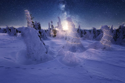 Scenic view of snowcapped field against sky at night