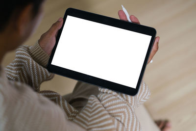 Midsection of woman using digital tablet