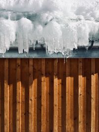 Close-up of icicles on fence during winter