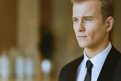 Close-up of thoughtful handsome businessman looking away in office