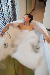 Young woman lying down in bathroom