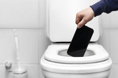 Cropped hand of person washing hands in bathroom