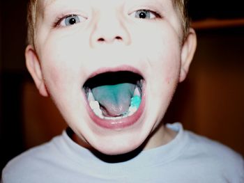 Portrait of smiling boy showing turquoise tongue