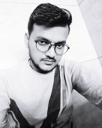 Portrait of young man wearing eyeglasses at home