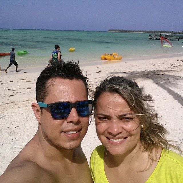 beach, sea, lifestyles, leisure activity, water, vacations, person, shore, sand, portrait, looking at camera, togetherness, enjoyment, sunglasses, happiness, smiling, young adult