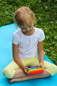 High angle view of boy playing with teddy bear while sitting at poolside