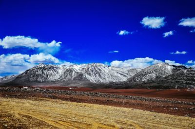 Scenic view of snowcapped mountains against blue sky