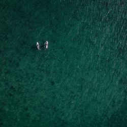 High angle view of paddle boarders at sea