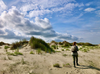 Rear view of man standing on land against sky