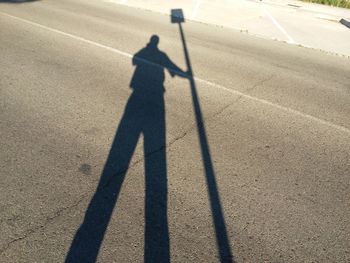 Shadow of man on road