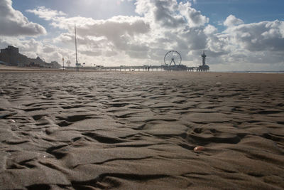 Low angle view scheveningen beach with blurred pier and ferris wheel in the background