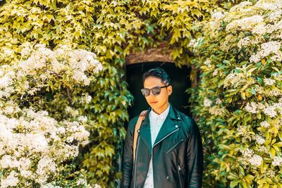 Portrait of man wearing sunglasses while standing against plants