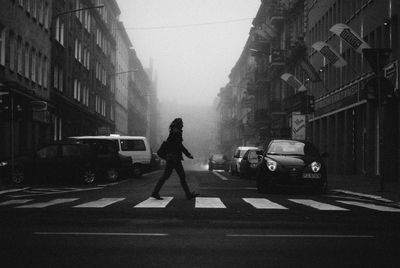 People walking on street against buildings in city