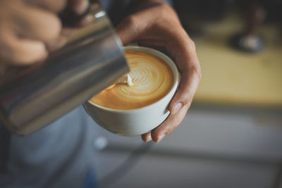 High angle view of hand holding coffee cup