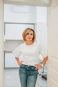 Portrait of young woman standing at home