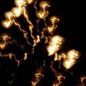 Low angle view of illuminated lights against sky at night