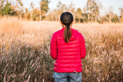 Rear view of woman standing on field