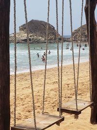 Panoramic view of swing on beach against sky