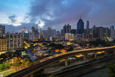 Aerial view of illuminated buildings in city against sky