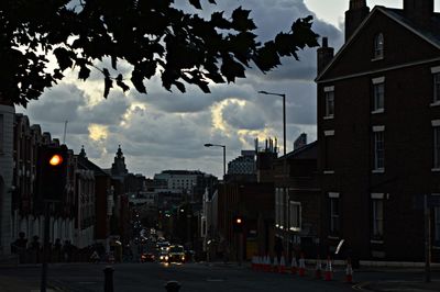 City street and buildings against sky at sunset